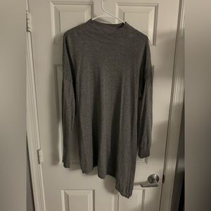 Asymmetrical heather gray long sleeve sweater. There is a slit on the long side